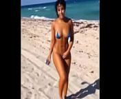 Sexy Latina in mini bikini on the beach from walk on the beach